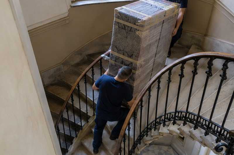 Armoire descendue dans un escalier tournant : chantier Avenue du Centre