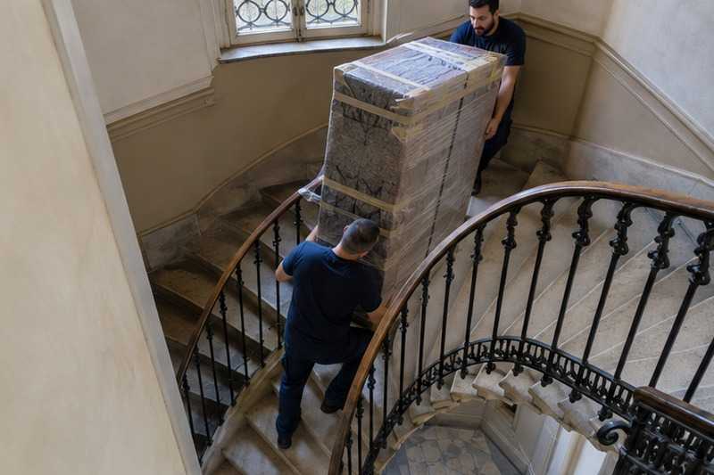 Armoire descendue dans un escalier tournant : chantier Rue Armand Noblet
